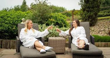 Two women in white robes sitting on chairs outside

AI-generated content may be incorrect.