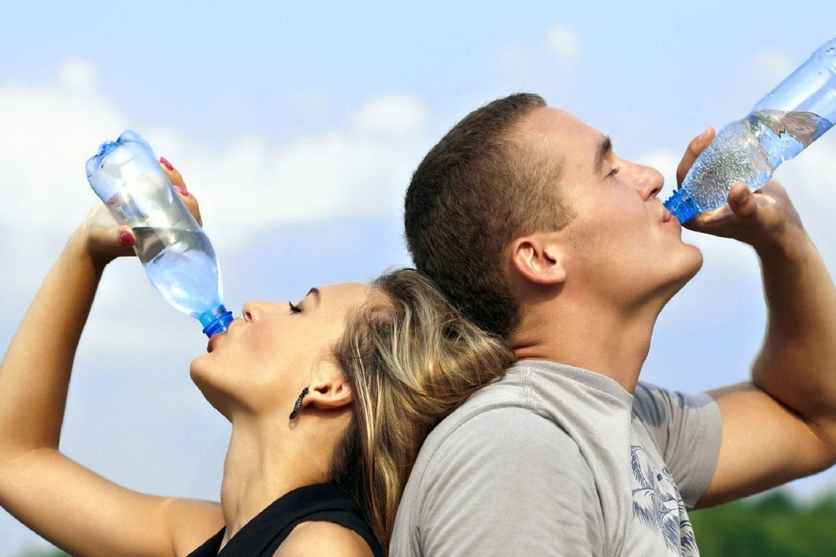 Couple drinking water from bottles