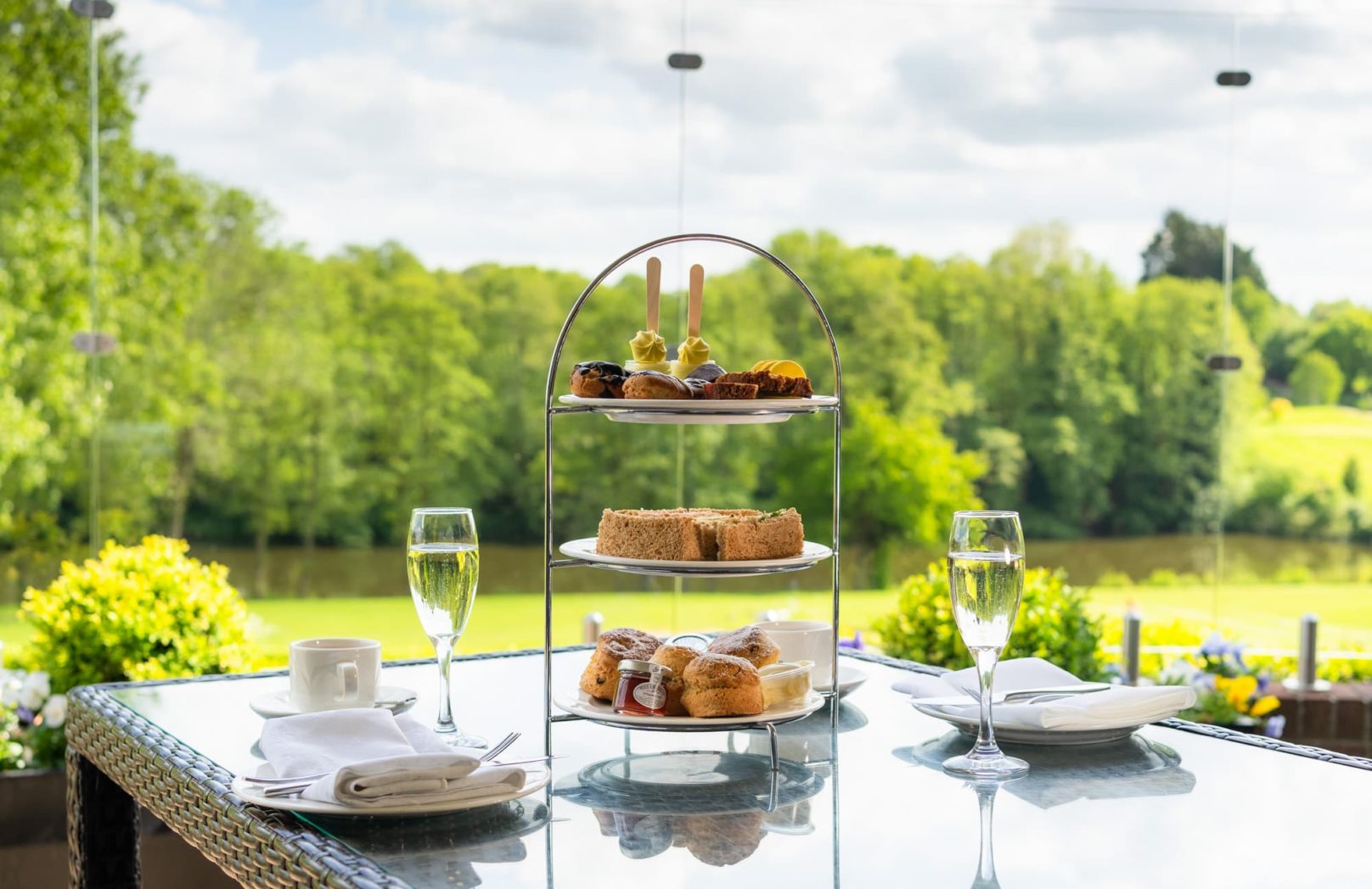 A stand of sweet Afternoon Tea with golasses or prosecco