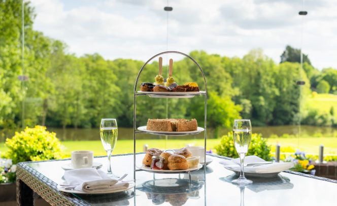 A stand of sweet Afternoon Tea with golasses or prosecco